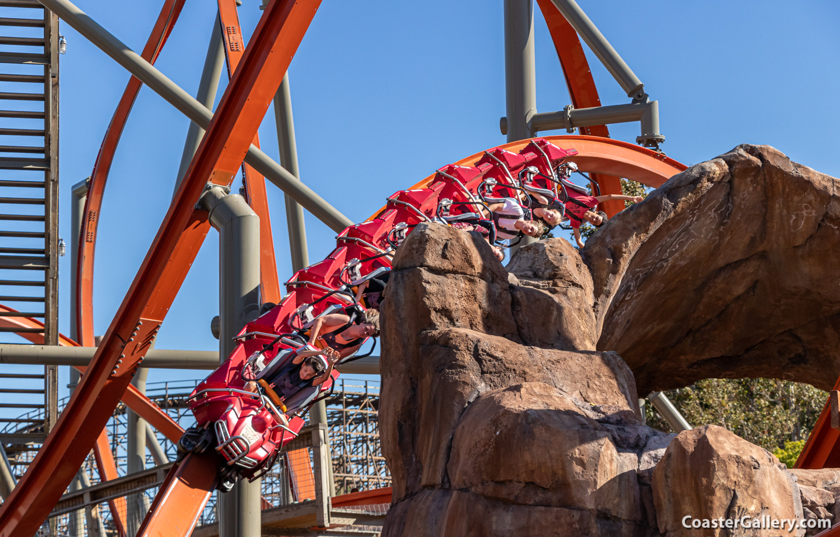 Single-rail roller coaster going past rocks and water